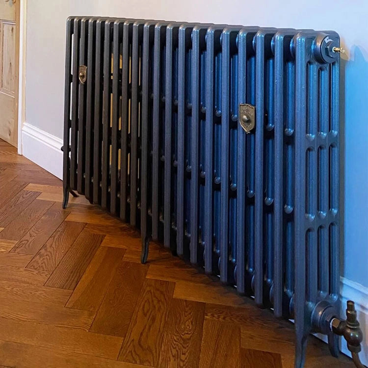 Arroll Neo Classic 4 Column Cast Iron Radiator fixed to a grey wall in a living space