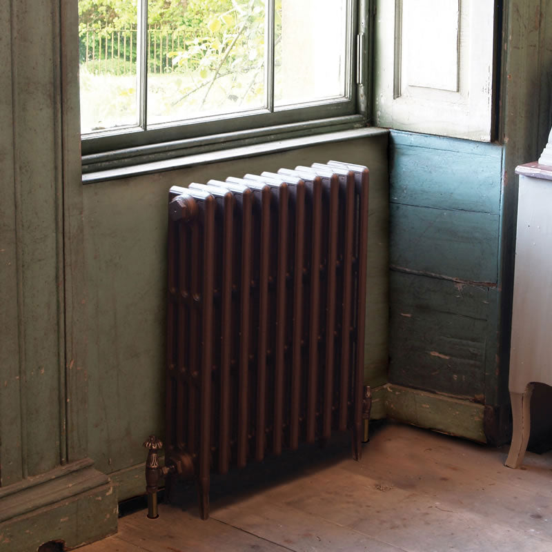 Carron Victorian 4 Column Cast Iron Radiator 810mm Height Special Finishes brown painted, lifestyle image of the radiator under the window of an out building
