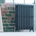 Arroll Edwardian 4 Column Cast Iron Radiator, next to a brick interior wall