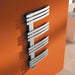 Carisa Adore Stainless Steel Towel Radiator fixed to a orange painted wall in a living space