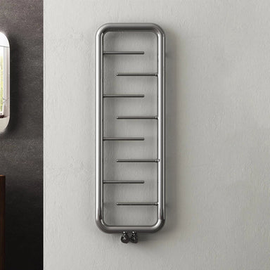 Carisa Aren Steel Designer Towel Radiator, fixed to a light grey wall in a bathroom space