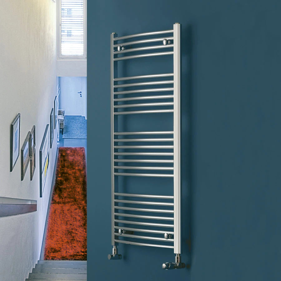 Eucotherm Chromo Curved Towel Radiator in a living space, wall hanging onto a ocean green painted wall