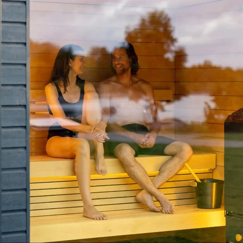 two persons sitting in a classic saunum sauna looking at each other